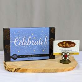Box of Celebrate assorted chocolates with florist business card on a wood tray