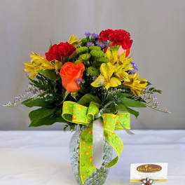 Mixed bouquet in a glass vase with red, yellow, and orange flowers