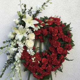 Red and white floral funeral wreath on a stand