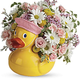 Yellow duck-shaped vase filled with pink and white flowers