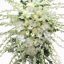 Large cascading white spray with roses, orchids, calla lilies, and hydrangeas