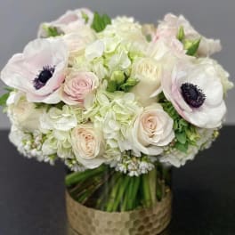Wedding bouquet of white and blush flowers in a gold vase