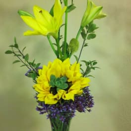 Tall yellow lily arrangement in a clear glass vase