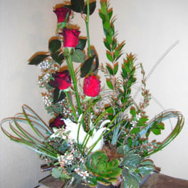 Tall arrangement of red roses and succulents in a black pot