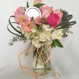 Pink and white flower arrangement in a mason jar vase