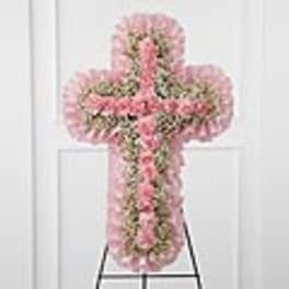 Pink floral cross-shaped funeral spray on an easel