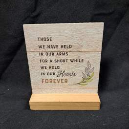 Wooden memorial plaque on a stand with a sympathy quote