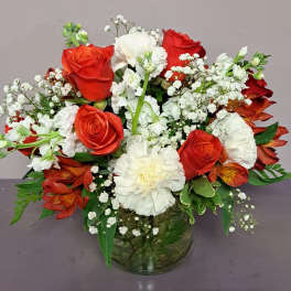 Red roses and white carnations in a glass vase with baby's breath