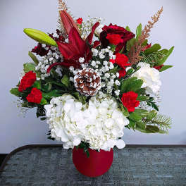 Red and white floral arrangement in a red vase