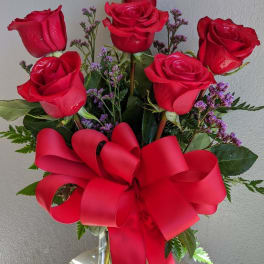 Bouquet of red roses with a large red ribbon in a glass vase