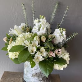 White floral arrangement in a birch-pattern vase with tall stems