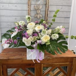 Mixed floral arrangement with white and pink blooms in a white box
