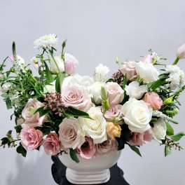 Pink and white rose arrangement in a white vase