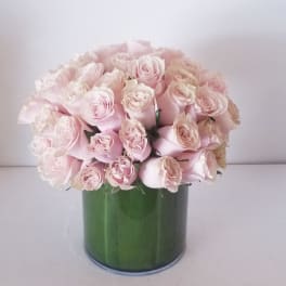 Bouquet of pale pink roses in a green cylindrical vase
