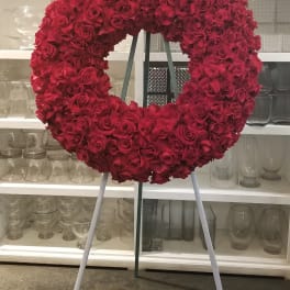 Large circular wreath of red roses on a stand
