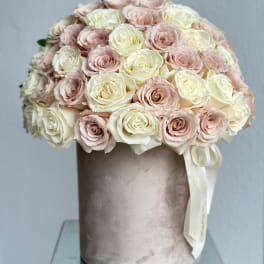 Round bouquet of pale pink and cream roses in a velvet hatbox