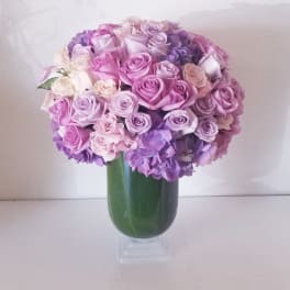 Bouquet of pink and lavender roses in a green vase