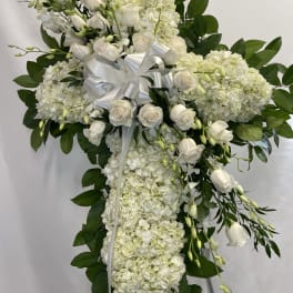 White floral standing spray with roses and hydrangeas on a ribboned easel