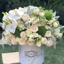 White and blush bouquet with orchids and roses in a marble-print box