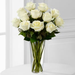 White roses arranged in a clear glass vase