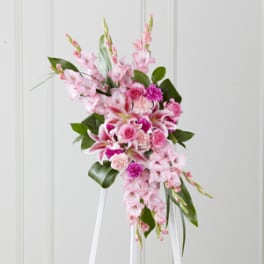 Pink floral standing spray on a white easel