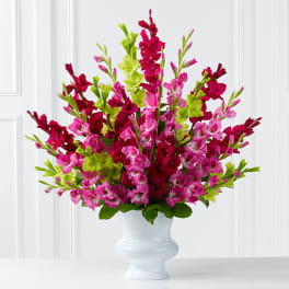 Pink and magenta flowers arranged in a white vase