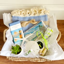 Gift basket with a small succulent, chocolates, cookies, and a woven textile