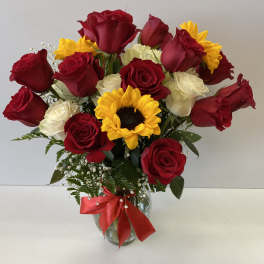 Bouquet of red and white roses with a sunflower in a glass vase