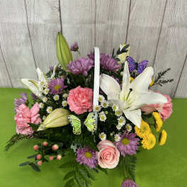 Basket arrangement with lilies, pink carnations, purple daisies, and butterflies