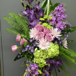 Purple and pink floral arrangement with roses, hydrangea, and tall blooms