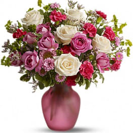 Pink and white rose bouquet in a frosted pink vase