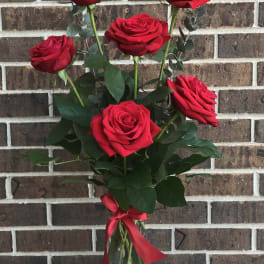 Bouquet of red roses in a glass vase with a red ribbon