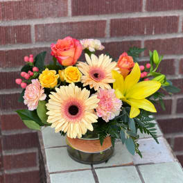 Mixed bouquet in a glass vase with roses, gerbera daisies, lilies, and carnations