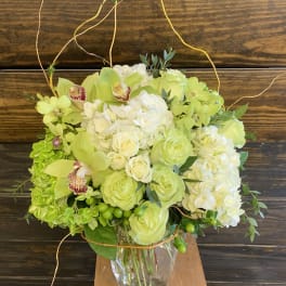 Lime green and white floral arrangement in a clear glass vase