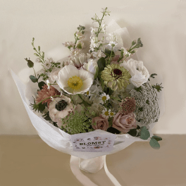 Bouquet of pastel flowers wrapped in white paper