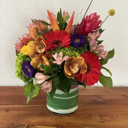 Colorful mixed bouquet in a green-striped glass vase