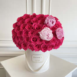 Hot pink and pale pink roses arranged in a white hat box
