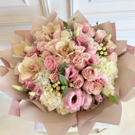 Bouquet of pink and cream flowers wrapped in blush paper
