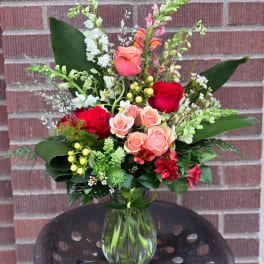 Mixed bouquet of roses and snapdragons in a glass vase