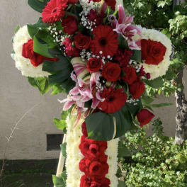 Standing floral cross with red roses and white flowers on an easel
