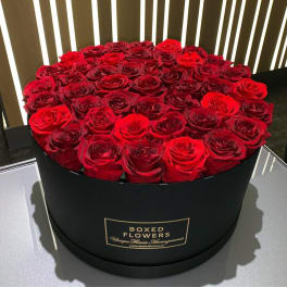 Round black box filled with red roses