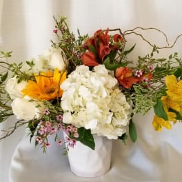 Mixed bouquet in a white vase with white, yellow, and red flowers