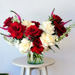 Red and white roses in a clear glass vase