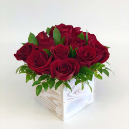 Red roses arranged in a white wooden box