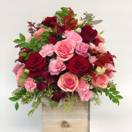 Pink and red rose arrangement in a wooden box