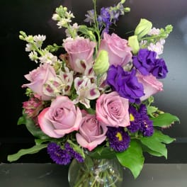 Pink and purple mixed bouquet in a clear glass vase