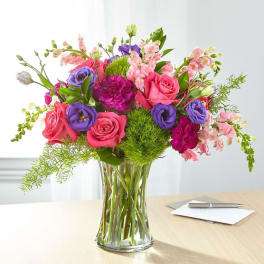 Bouquet of pink and purple flowers in a clear glass vase