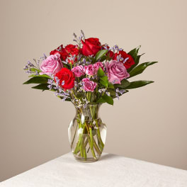 Bouquet of red and pink roses in a clear glass vase