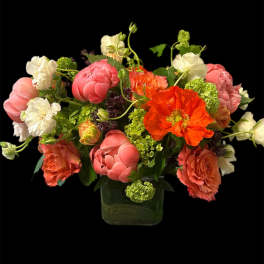 Mixed bouquet of pink, white, and orange flowers in a glass vase