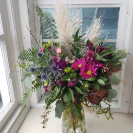 Mixed bouquet in a clear glass vase with pink and purple blooms